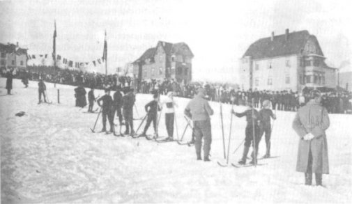 [billede: flere skiløbere, huse i baggrund]